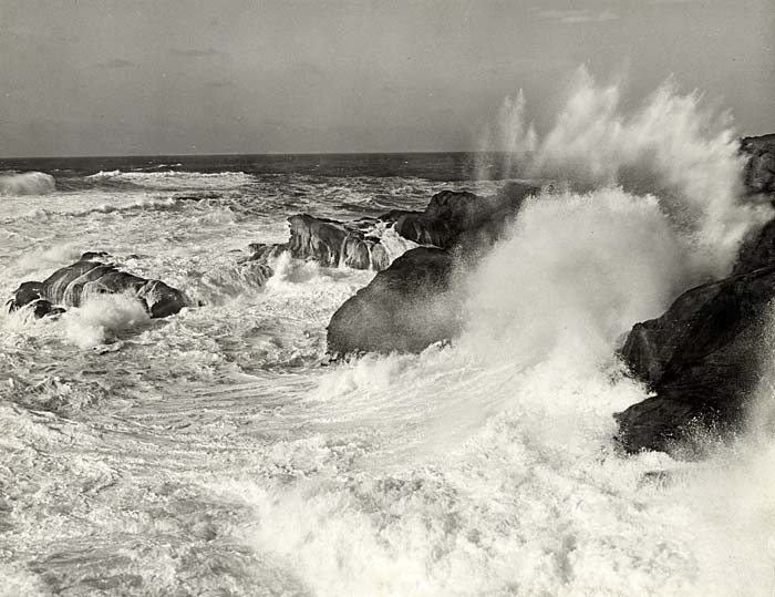Waves crash against a rocky shore line.
