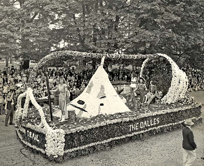 A float in the rose festival parade from The Dalles features women partaking in recreational activities such as skiing, fishing.