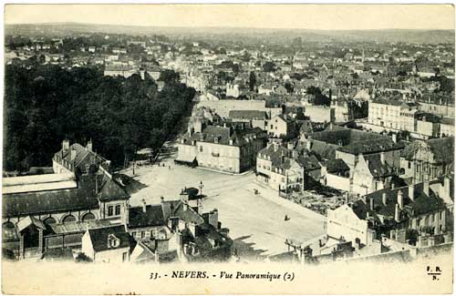 High view of Nevers France showing rooftops on right and a park full of trees on left.