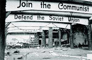 Archway reads "Join the Communist, Defend the Soviet Union" in a rundown, ruin structure.
