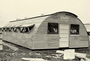 A quonset hut. A lightweight prefabricated structure of corrugated galvanized steal with semicircular roof. 