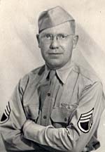 Photo of Bill DeCew in military uniform. He's wearing glasses & has arms crossed in front.