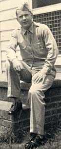 Photo of Sidney Hoffman in military uniform sitting on brick step outside a building.