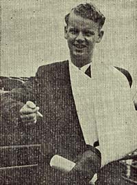 Photo of Ivan Jacobsen with left arm in a sling. He holds a cigarette in the right hand.