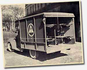 Ambulance from 1939 with back door open to show room for stretchers inside.