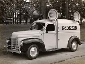 1940s truck with sirens on top and word "Signal" printed on side.