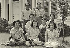 Family of 8 pose before their typical American house.