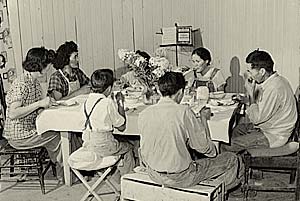 Family of 7 seated around a table eating.