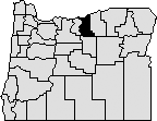 Map of Oregon with a section in the north-center blacked out to indicate Gilliam County.