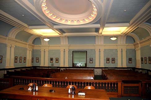 Wooden audience benches in 3 rows as seen from judge's bench in Clatsop County Courthouse.