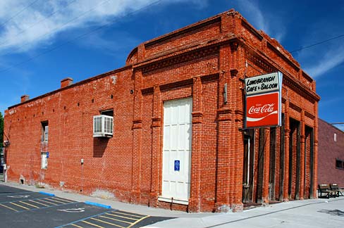 Brick building on corner of block with Coca-cola sign out front.