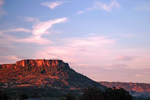 Rock formation with a flat top, hence it's name being Table Rock with sunset in back.