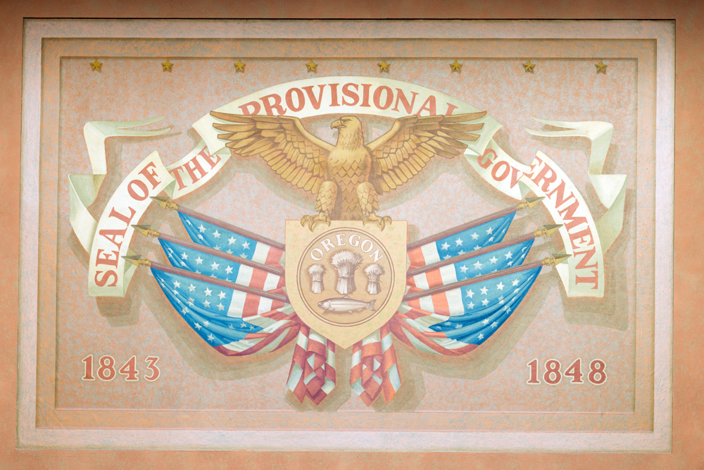 The seal of the provisional government with an eagle atop a sheild with 3 flags coming out of each side.