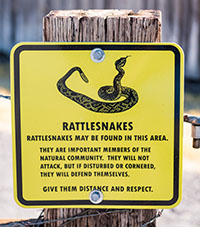 Warning sign for rattlesnakes says "Rattlesnakes may be found in this area."