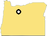 Shape of the State of Oregon with a marker in the upper middle section denotes the location of the town of Antelope.