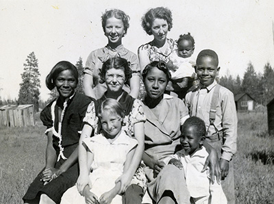 3 white women and 2 black women pose with their children for a photo. 