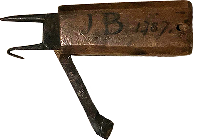 A metal tool for marking timber. It has the initials J and B with the date 1787 marked on the handle.