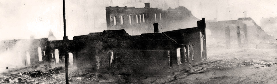 Old photo shows burned out buildings in Sumpter after the fire of 1917. Only a few brick walls stand.