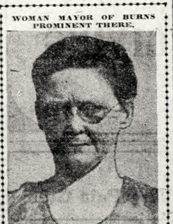 Newspaper photo of woman wearing glasses. Over her photo it reads: Woman Mayor of Burns Prominent There 