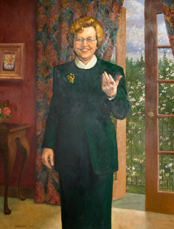 Painting of Barbara Roberts standing before an open French Door leading to a garden.