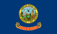 Idaho flag is dark blue with the state seal in the center. Under the seal is written: State of Idaho