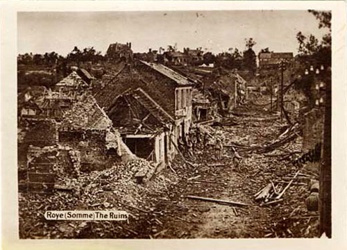 Village houses in ruins with rubble strewn in the street.