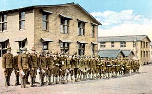 Soldiers stand in a long line in front of hospital building during WWI