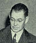 Photo of James Olson in suit and tie.