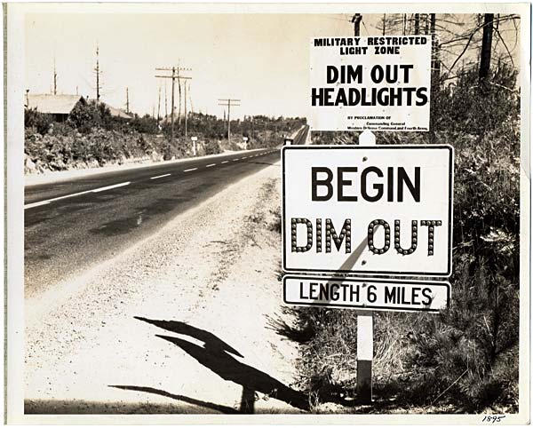 Road side sign reads "Begin Dim Out Length 6 miles" "Dim out headlights"