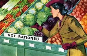 A woman in hat, coat & gloves at the super market picking up a cabbage in the vegetable section.