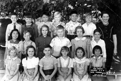 18 students & 1 teacher pose for school picture. Children are mix of boys, girls, Japanese descent and non.