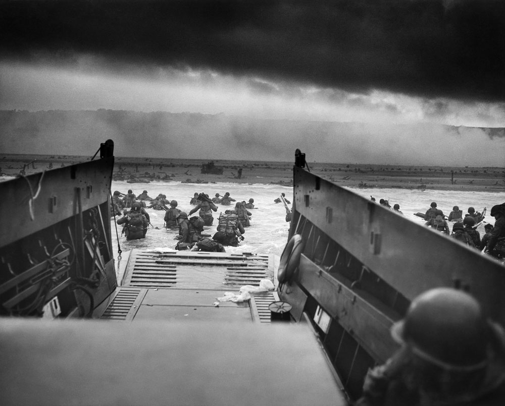 Photo of soldiers exiting a boat onto the beach.