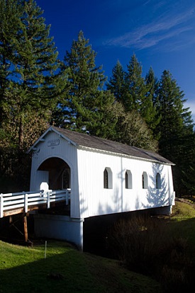 Covered bridge with walls and 4 windows in side.