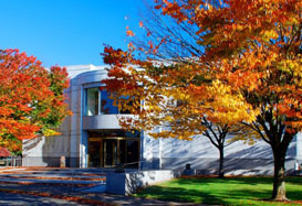 Exterior view of the state archives building during fall. Colorful trees stand in front.