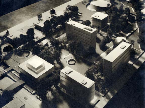 Model of buildings, streets and trees sits on desk top.
