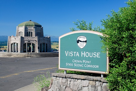 Vista house has a dome roof and a sign out front says Vista House Crown Point