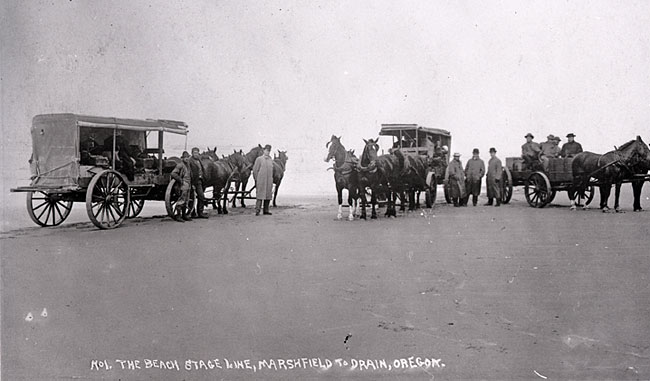 Black and white photo of stagecoaches and a wagon on the beach in 1910.