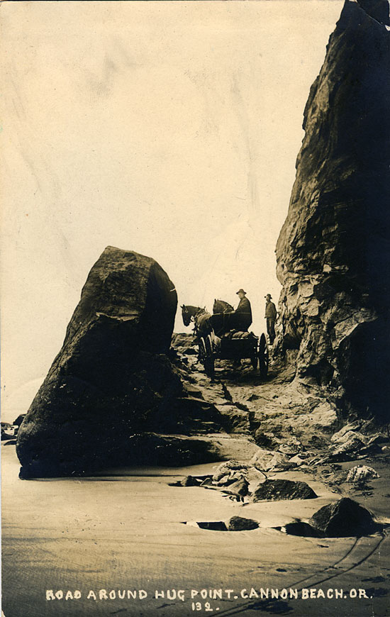 2 men and a horse drawn wagon traveling up a rocky trail on the Oregon coast.