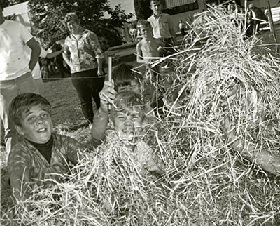 Two boys look for a needle in a haystack