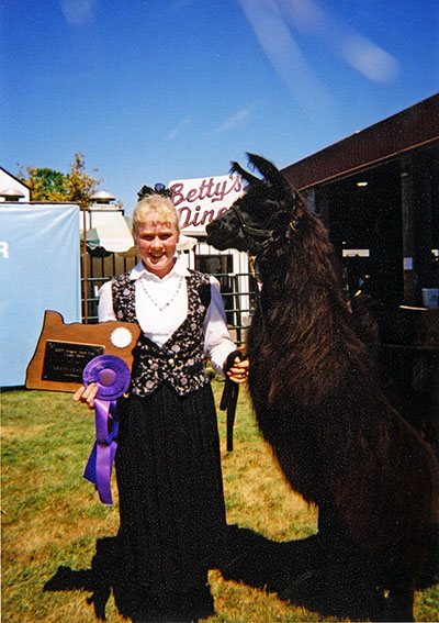 A girl poses with a llama