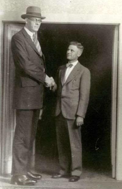 Giant man Clifford Thompson stand with a smaller man