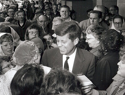 Senator John Kennedy campaigns for the presidency in 1960 with a crowd at the State Fair