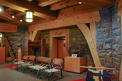 The lobby of Timberline lodge with walls made of large stone slabs. Rustic wooden furnishings built during the Depression.