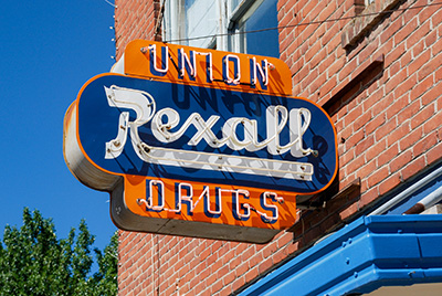 Sign attached to a brick building reads Union Rexall Drugs.