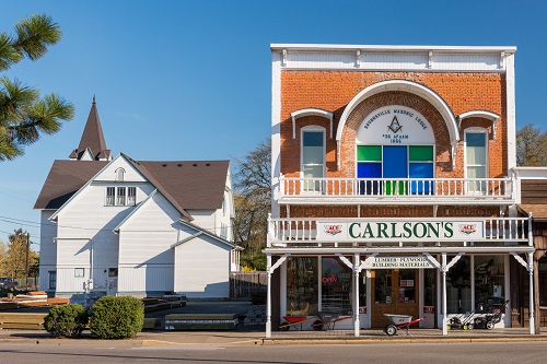 On the left a church and on the right a general store with the name "Carlson's" over the top.