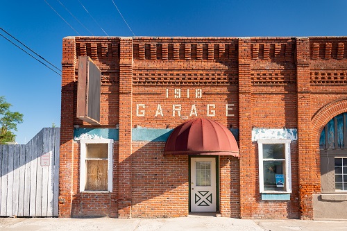 A red brick building with the year 1918 and the word garage in white brick above the front door.