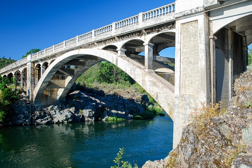 A concrete arch bridge spanning a river.