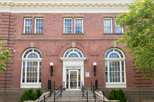 a two-story brick building with the inscription CITY HALL above the entrance.