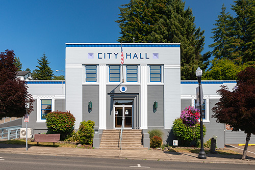 Single story building with 1st floor raised above the sidewalk a few feet. Stairs lead up from sidewalk to double font doors.