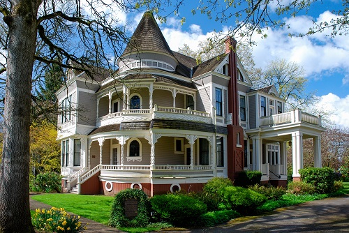 Medium to large frame house in the late Queen Anne style. Central block of the 2-story structure has a hip roof. Projecting wings to north & east are gabled. 2nd story of east wing overhangs a bay window. Northeast corner of main block is rounded surmounting in a tower with a conical candle-snuffer roof, and has concentric 2-story porch.